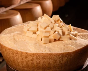 Sacchetto di bocconcini di Parmigiano Reggiano 12 mesi sopra una forma intera.