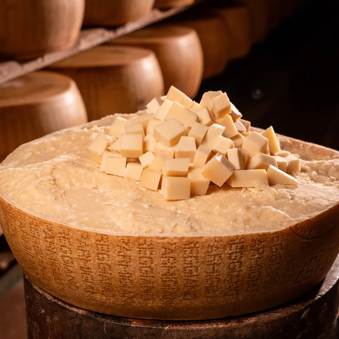 Sacchetto di bocconcini di Parmigiano Reggiano 12 mesi sopra una forma intera.