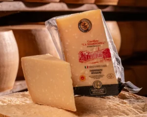 Pezzo di Parmigiano Reggiano 36 mesi con cristalli di tirosina evidenti su forma.