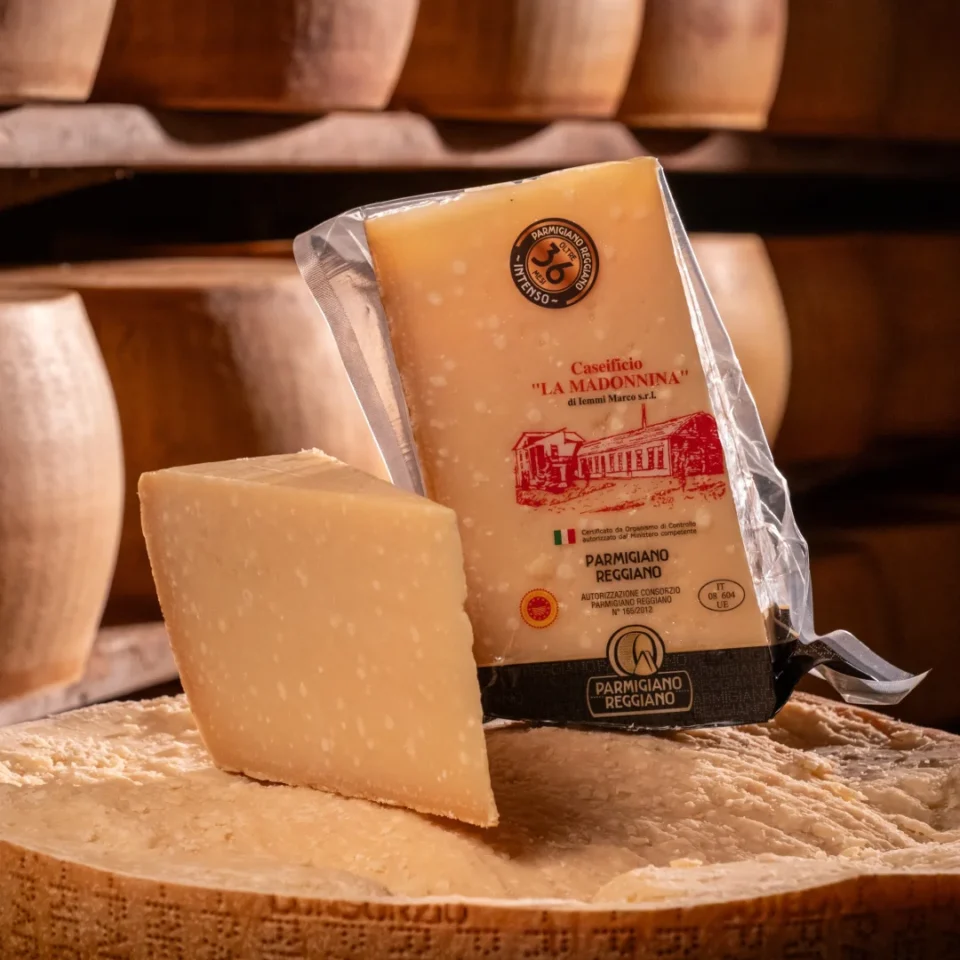 Pezzo di Parmigiano Reggiano 36 mesi con cristalli di tirosina evidenti su forma.