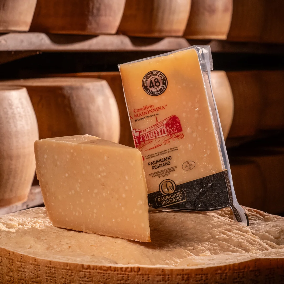 Parmigiano Reggiano 48 mesi "Stravecchio" posizionato sopra la forma di formaggio.